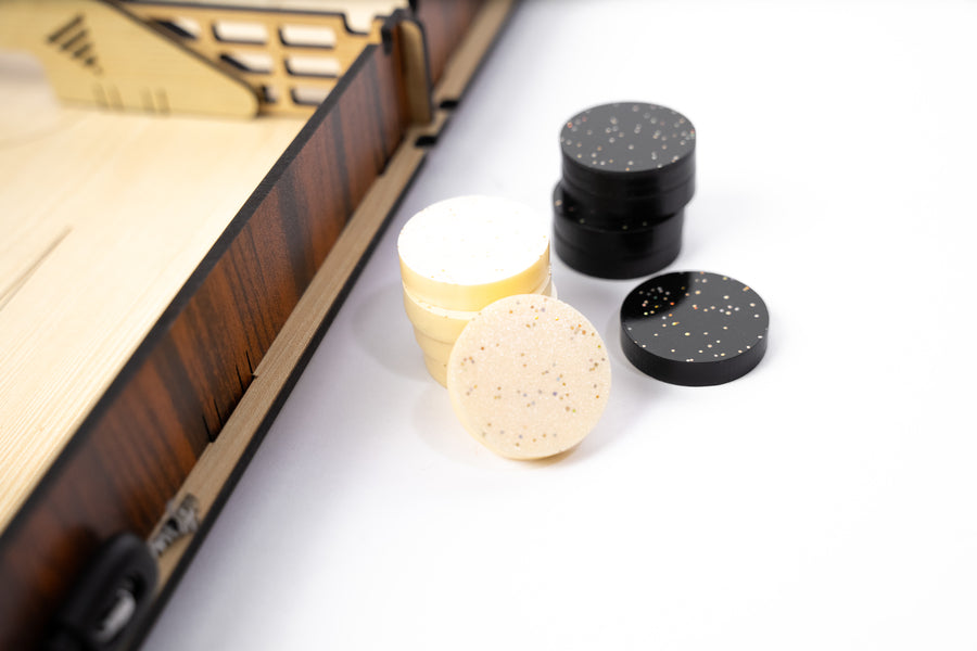 Laser-cut wooden Slingshot game board with central divider and dual elastic bands. Several circular pucks are scattered across both sides, ready for a fast-paced match.