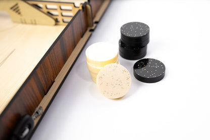 Laser-cut wooden Slingshot game board with central divider and dual elastic bands. Several circular pucks are scattered across both sides, ready for a fast-paced match.