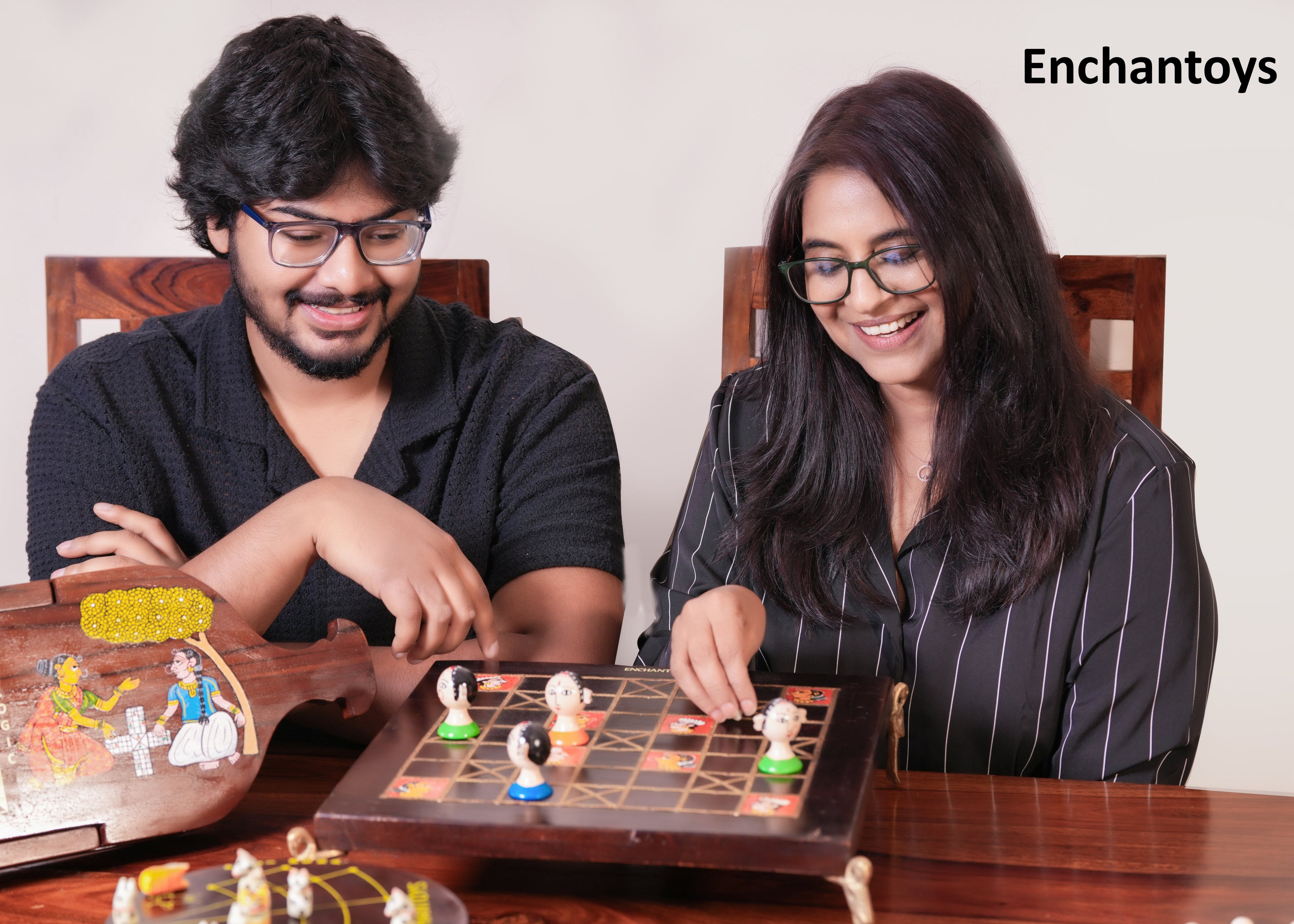 Two people playing a board game with Enchantoys 